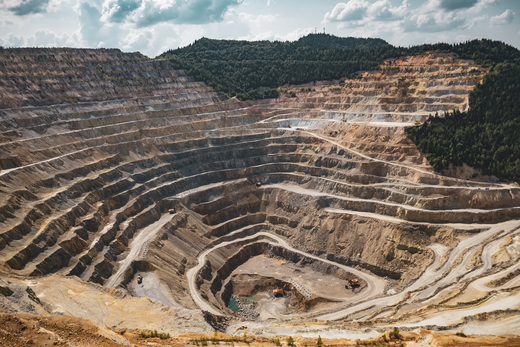 Terraced benches and haul roads in an open-pit mine, seen from the rim
